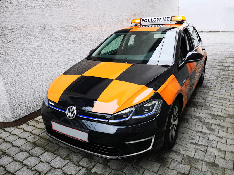 Amber lightbar with 'Follow Me' sign on airport car